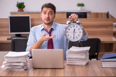 Ofisteki aşırı işten memnun olmayan genç bir erkek işçi.