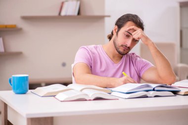 Evde sınava hazırlanan genç bir erkek öğrenci.