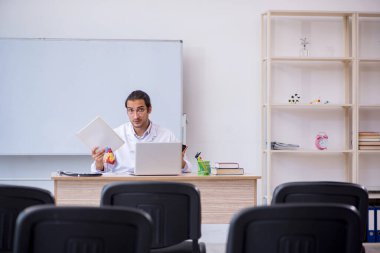 Genç erkek doktor sınıfta seminer veriyor.