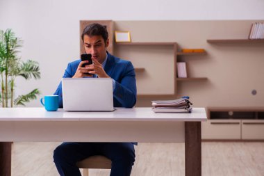 Genç erkek çalışan salgın sırasında evden çalışıyor.