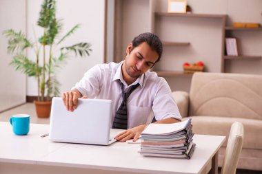 Genç erkek çalışan salgın sırasında evden çalışıyor.