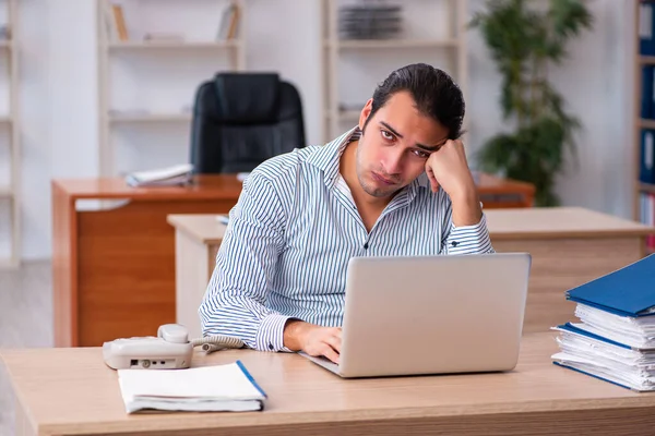 Jonge mannelijke werknemer ongelukkig met overmatig werk — Stockfoto