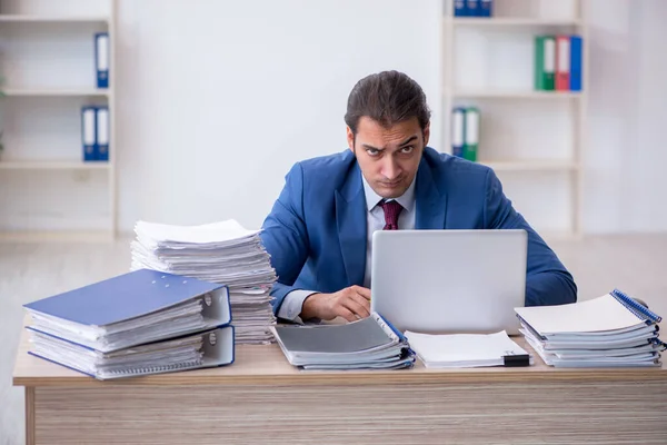 Giovane dipendente maschio infelice con un lavoro eccessivo in ufficio — Foto Stock