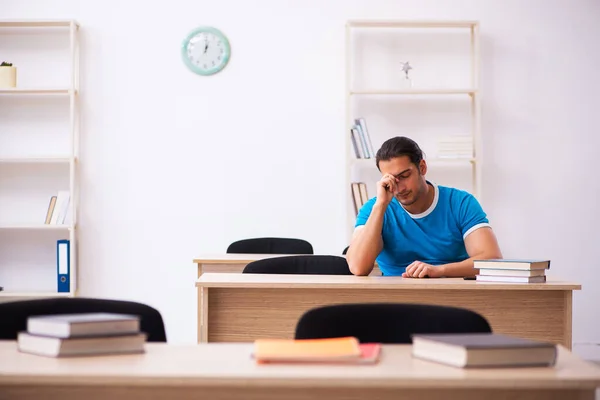 Estudiante agotado preparándose para los exámenes en el aula — Foto de Stock