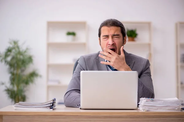 Jonge mannelijke werknemer ongelukkig met overmatig werk in het kantoor — Stockfoto