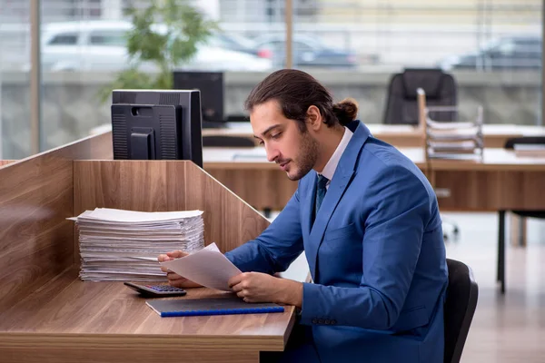 Jovem funcionário masculino infeliz com excesso de trabalho no escritório — Fotografia de Stock