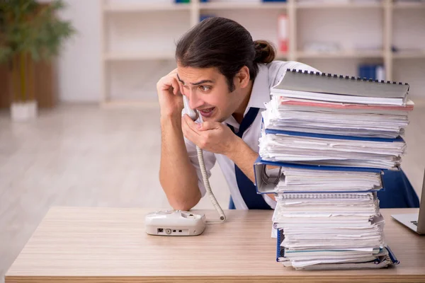 Junge männliche Mitarbeiter und viel Arbeit im Büro — Stockfoto