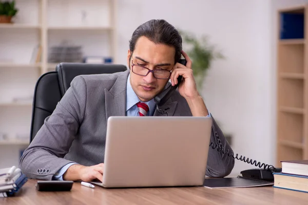 Junge männliche Mitarbeiter sitzen am Arbeitsplatz — Stockfoto