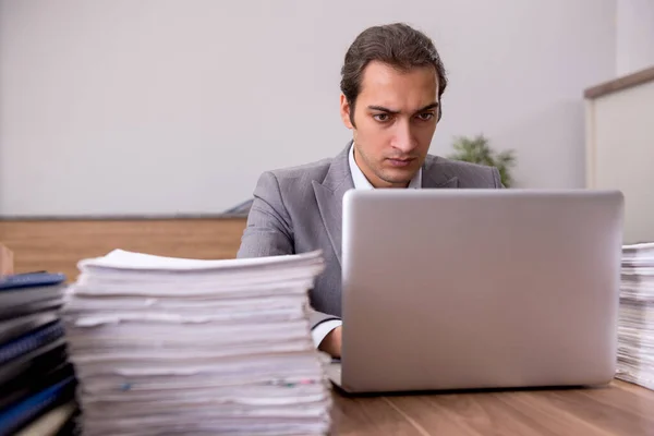 Jovem funcionário masculino infeliz com excesso de trabalho no escritório — Fotografia de Stock