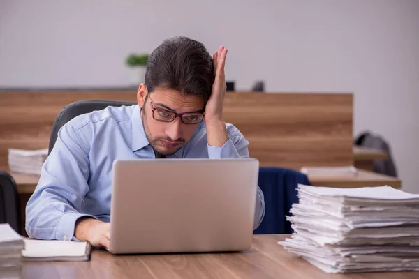 Jeune employé masculin et trop de travail au bureau — Photo