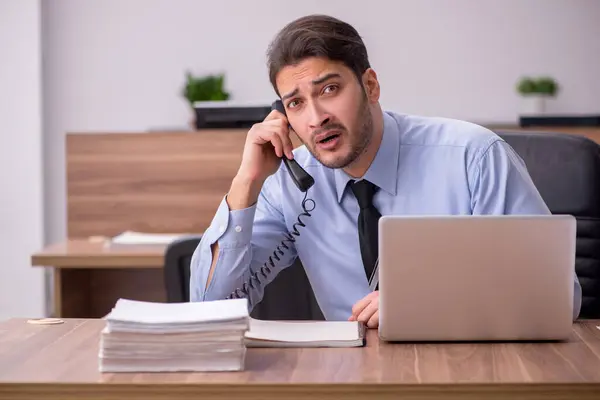 Junge männliche Mitarbeiter und zu viel Arbeit im Büro — Stockfoto