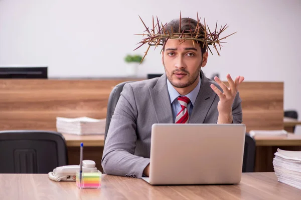 Junge männliche Angestellte trägt stacheligen Kranz auf dem Kopf — Stockfoto