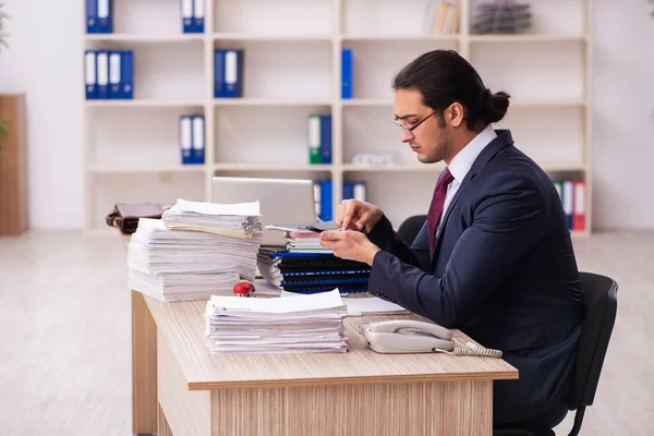 Joven empleado masculino infeliz con el trabajo excesivo — Foto de Stock