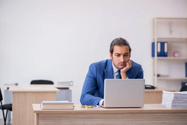 Young male employee and too much work in the office — Stock Photo, Image