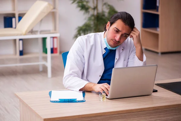 Jonge mannelijke arts werkzaam in de kliniek — Stockfoto