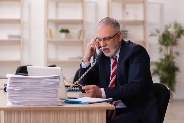 Velho empresário empregado sentado no escritório — Fotografia de Stock