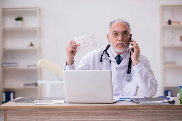 Gammal manlig läkare kardiolog arbetar på kliniken — Stockfoto