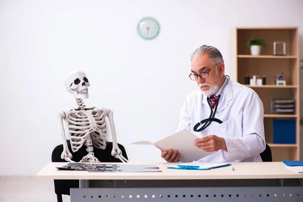 Anciano médico y paciente esqueleto en la clínica — Foto de Stock