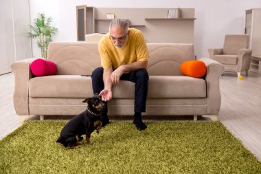 Evde köpeği olan yaşlı bir adam.