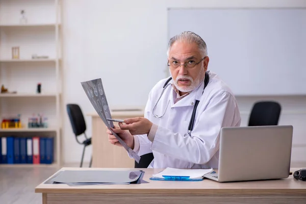 Klinikte çalışan yaşlı bir erkek radyolog. — Stok fotoğraf