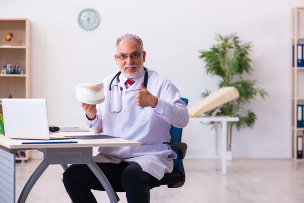 Boynuna tasma takan yaşlı bir doktor. — Stok fotoğraf