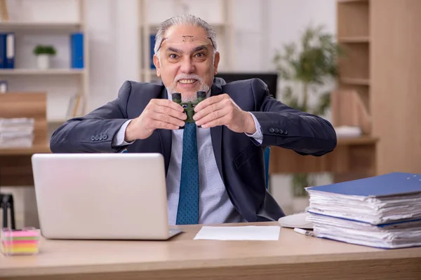 Old male employee auditor holding binoculars at workplace — Stock Photo, Image