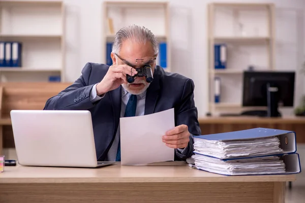 Velho funcionário auditor segurando binóculos no local de trabalho — Fotografia de Stock