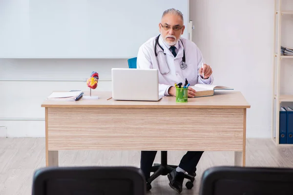 Starý lékař přednášející ve třídě během pandemie — Stock fotografie
