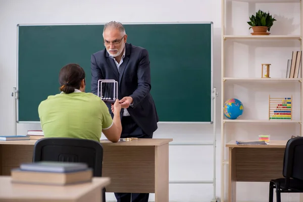 Leeftijd fysica leraar en mannelijke student in de klas — Stockfoto