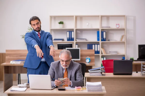 Viejo jefe y joven empleado masculino en concepto de remuneración —  Fotos de Stock