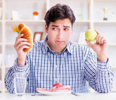 Diyet dolandırıcılığında sağlıklı yemek ve ekmek arasında ikilem yaşayan bir adam.