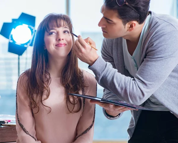 Hombre haciendo maquillaje para mujer linda en salón de belleza —  Fotos de Stock