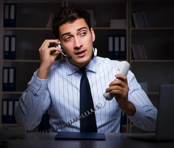 Operador de call center conversando com o cliente durante o turno da noite — Fotografia de Stock