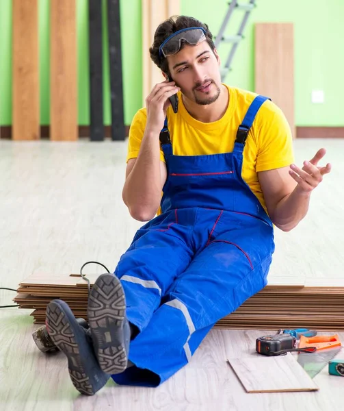 Empreiteiro profissional que coloca piso em casa — Fotografia de Stock