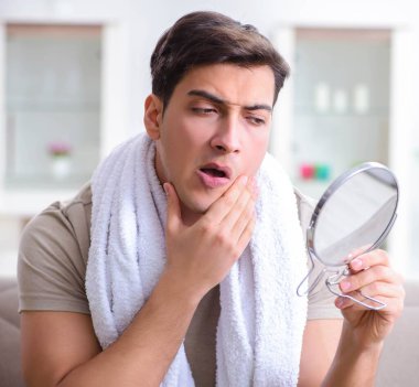 Adam evde tıraş olmaya hazırlanıyor.