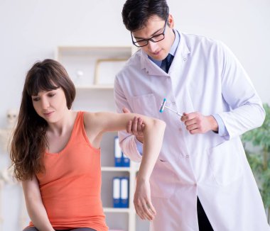 Doktor nörolog kadın hastayı muayene ediyor.