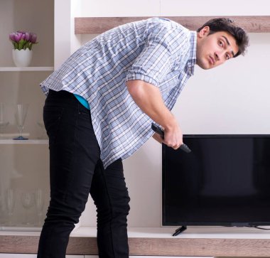 Bozuk televizyonu tamir etmeye çalışan adam