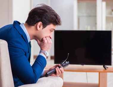 İş adamı ofiste televizyon izliyor.