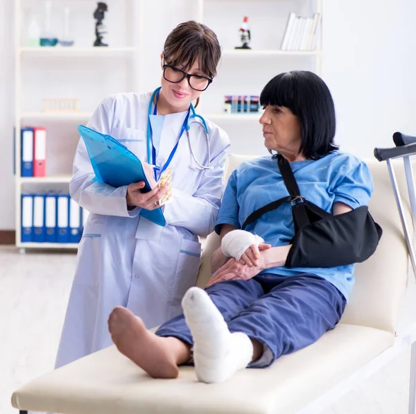 Doctor examining old mature woman after incident — Stock Photo, Image