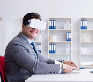 Ofiste sanal gerçeklik gözlüklü bir iş adamı var.