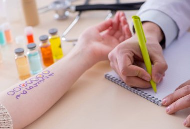 Hastanedeki hastanın alerji reaksiyonunu test eden doktor.