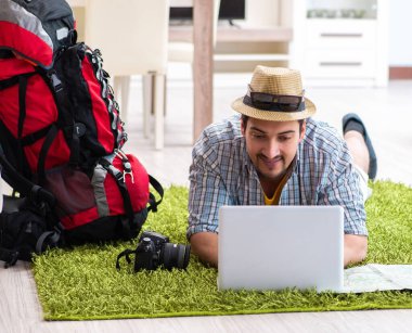 Genç adam internetten seyahat etmeyi planlıyor.