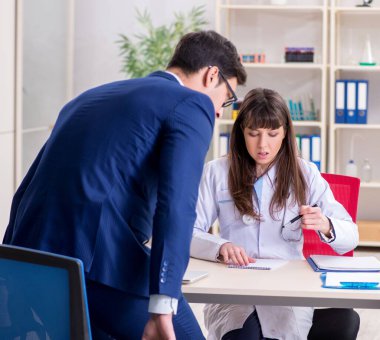 İş adamı doktorla sağlık sorunlarını tartışıyor