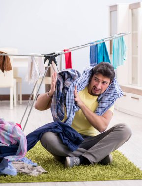 Yakışıklı koca evde çamaşır yıkıyor.