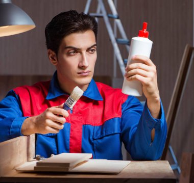 Genç adam ahşap parçaları DIY konseptinde yapıştırıyor.