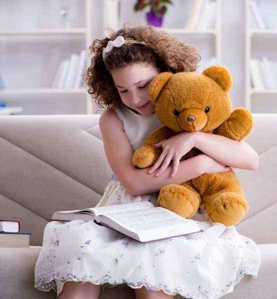 Klein mooi meisje die thuis boeken leest — Stockfoto