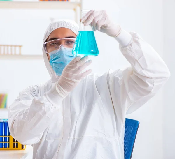 Jovem estudante de química que trabalha em laboratório em produtos químicos — Fotografia de Stock