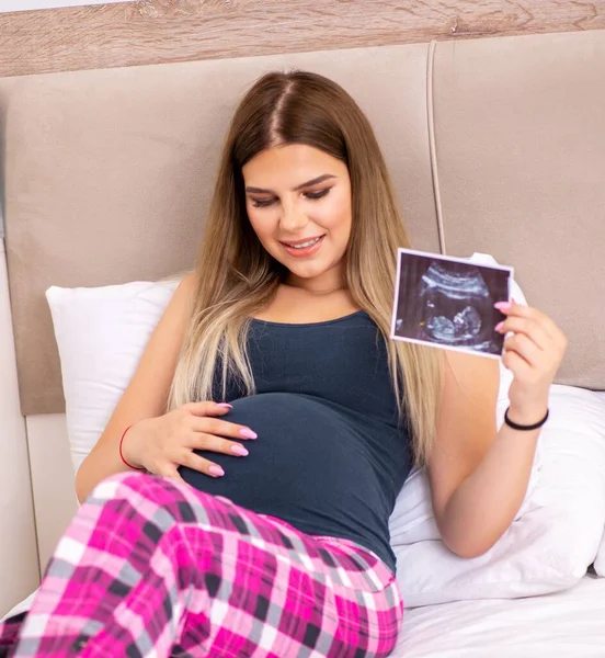 幸せな若いです妊娠中の女性でベッド — ストック写真