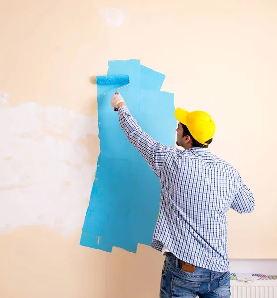 Pintor homem pintando a parede em casa — Fotografia de Stock