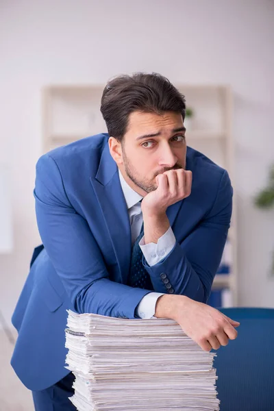 Joven empleado masculino descontento con el trabajo excesivo en la oficina — Foto de Stock